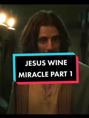 The image features a man with long, dark hair and a beard, centered in the frame and looking towards the viewer. A colorful text overlay, with a black rectangle and vibrant teal above a red rectangle, which reads "JESUS WINE MIRACLE PART 1". The background appears dimly lit, possibly indoors, with blurred details suggesting a historical or theatrical setting. The man is wearing a robe-like garment.
