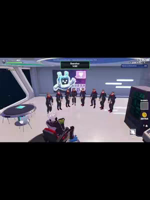 A group of stick figures wearing dark suits and red ties stand in a circle inside a brightly lit room. Their backs are to the camera, and they appear to be interacting with an avatar figure suspended in the air with a sign that says "buddy". The setting is a futuristic, indoor environment with bright lighting.