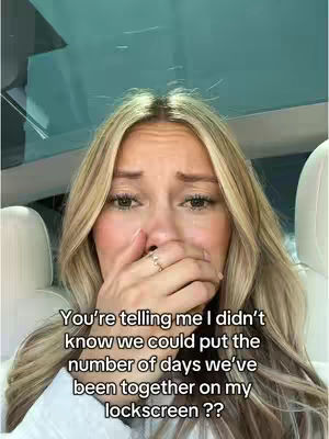 A young woman with blonde hair is shown in a selfie, covering her mouth with one hand. Her expression suggests a range of emotions, possibly surprise or sadness. The background is blurred, but appears to be inside a vehicle. Text is overlaid on the image.