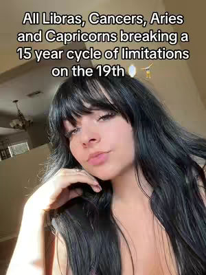 A woman with long black hair and bangs is in a selfie shot. The overlaying text at the top, in white, reads "All Libras, Cancers Aries, and Capricorns breaking a 15-year cycle of limitations on the 19th."