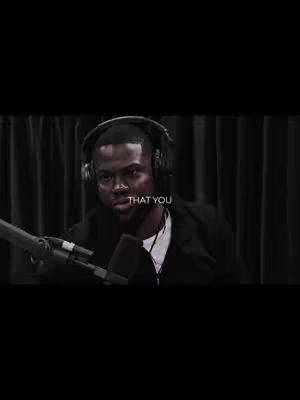 The cover image shows a man seated, wearing headphones and speaking into a microphone with a microphone boom. The background is a blurred curtain. The image has a dark, somewhat desaturated aesthetic.