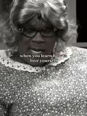 A black-and-white close-up of a person in a wig and glasses, likely portraying a character. Text overlayed on the image reads, 'when you learn how to love yourself'. The person appears to be looking down. The image is composed with a focus on the upper body.