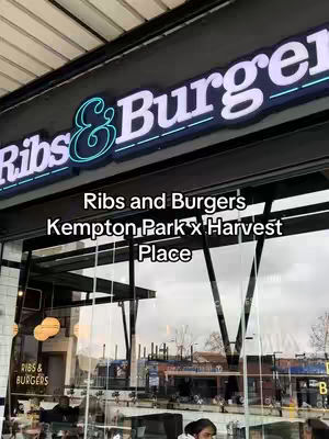 The cover image shows the exterior of a restaurant called "Ribs & Burgers." The restaurant sign is prominently displayed, with the words in large, illuminated letters, the "&" symbol highlighted with a turquoise glow. Below the sign, text indicates the location as "Kempton Park x Harvest Place." Through the large glass windows, there are glimpses of the interior, with seating areas.