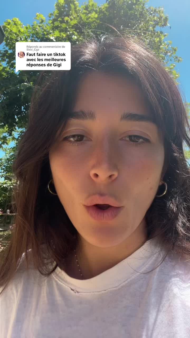 The cover image features a young woman with brown hair and fair skin, centered in the frame. She is looking directly at the camera with her mouth slightly open, as if speaking, and has gold hoop earrings. The background is a blur of green foliage and bright blue sky, suggesting an outdoor setting with natural light. A white comment box with text is overlaid on the scene.