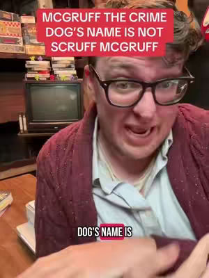 A man with glasses is looking into the camera and talking, with a red banner above his head which says, "McGruff the crime dog's name is not Scruff McGruff" and a smaller banner that says, "DOG'S NAME IS" underneath the middle of his face.