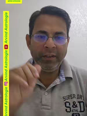 A middle-aged man with short dark hair, wearing glasses and a gray polo shirt, is centered in a vertical frame. A gold and yellow vertical rectangle borders the left side, with text in a vertical orientation. The background is plain. The man is looking at the camera and gesturing with his right hand.