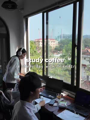 The photo captures a bright indoor scene with two individuals studying in front of a large window overlooking a cityscape. The scene is well-lit, with soft natural light illuminating the subjects and creating a relaxed atmosphere. The text overlay on the image introduces the video content.