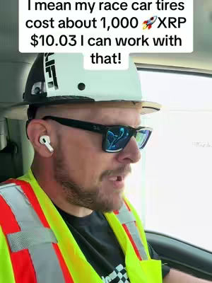 A man wearing a hard hat, sunglasses, and a reflective vest is speaking from inside a vehicle. Overlaid text appears at the top, and he's wearing an earbud in one ear.