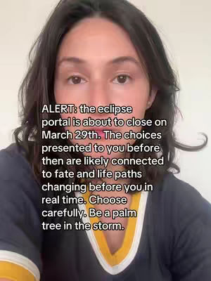 A medium shot shows a fair-skinned woman with dark hair looking directly at the camera. She has a neutral expression. Overlaid text fills the lower portion of the frame, and she is wearing a navy shirt with yellow and white accents around the neck. The background is a plain, light-colored wall.