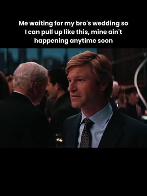 The cover image is a still from a film, showing a man in a suit smiling slightly, with other people blurred in the background at what appears to be an event. Text is overlaid at the top describing a relatable experience about wedding plans, playing on the man's expression.