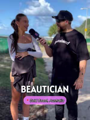 A man in a black t-shirt with the word 'getahead' on the front, wearing sunglasses and a cap, interviews a woman on the street. The woman smiles, holding a microphone, both standing in front of a blurred background. Text on the image reads 'BEAUTICIAN, Gold Coast, Australia.'