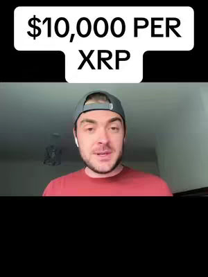 The cover image is a vertical video frame featuring a man in a casual setting. Above him, a white banner displays the text "$10,000 PER XRP" in black block letters. The man is centrally positioned, wearing a red shirt and a gray baseball cap. He is facing directly towards the camera, with a calm expression on his face. The background appears to be a room with a neutral wall, and the lighting suggests an indoor environment. The composition is straightforward, with the text overlay drawing immediate attention.