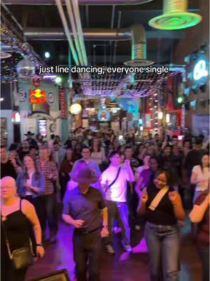 An interior shot of a crowded bar or nightclub with a large group of people. Overhead, there's a line of lights. The hook text is placed on the top of the image.