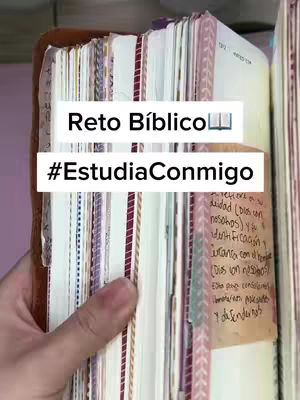 The image shows an open Bible held in a hand. The Bible is open to a specific page with handwritten notes and sticky notes. Overlaid on the image are two white text boxes: the first says "Reto Bíblico" (Biblical Challenge) and the second says "#EstudiaConmigo" (#StudyWithMe).