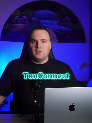 A man is centered in the frame with light blue and purple ambient lighting. He is wearing a black t-shirt with text overlay.