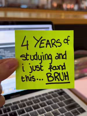 A hand holding a bright yellow sticky note with black handwritten text against a blurred background of a laptop and a wooden surface. The note reads: '4 YEARS of studying and i just found this... BRUH'.
