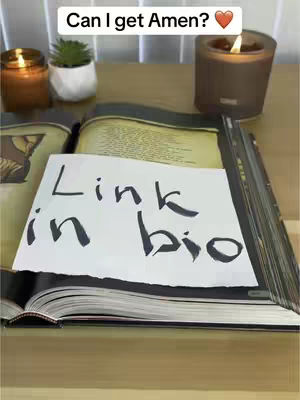 The cover image features a close-up shot of a book with a handwritten note that says 'Link in bio'. There are candles, a small plant, and a wooden surface which likely serves as a table.