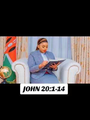 A woman in a blue suit sits in a white chair, reading a book. The background includes curtains and a flag. Text overlayed at the bottom reads "JOHN 20:1-14".