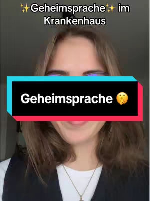 A woman with light brown hair is centered in the frame. The background is slightly blurred, suggesting an indoor setting. She's wearing a dark vest over a white shirt and a necklace.
Two text overlays: The top text reads 'Geheimsprache im Krankenhaus' ('Secret Language in the Hospital') with sparkles on each side. A rectangular overlay in the center of the image has the text 'Geheimsprache' ('Secret Language') with a whispering face emoji. The colors in the overlay are black, red, and blue.