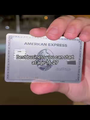 A hand holding an American Express credit card. Text overlay reads: "Best business you can start at age 16-27". The background is blurred, suggesting an indoor setting.