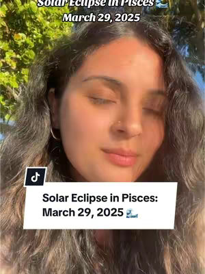 The cover image features a woman with long, wavy brown hair against an out-of-focus background of green foliage and a blue sky. The woman is looking down with her eyes closed. Added to the image is a white rectangular label at the bottom with the text 'Solar Eclipse in Pisces: March 29, 2025'. A black TikTok logo is in the top left corner. The color palette is natural with greens, blues, and the woman's skin tones predominating.