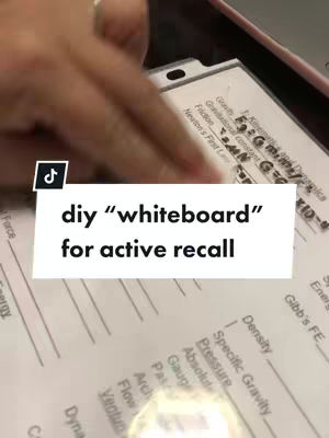 A hand is shown partially covering a white piece of paper filled with handwritten notes and formulas. A text overlay reads "diy 'whiteboard' for active recall". The background suggests an indoor setting, possibly a desk or table.