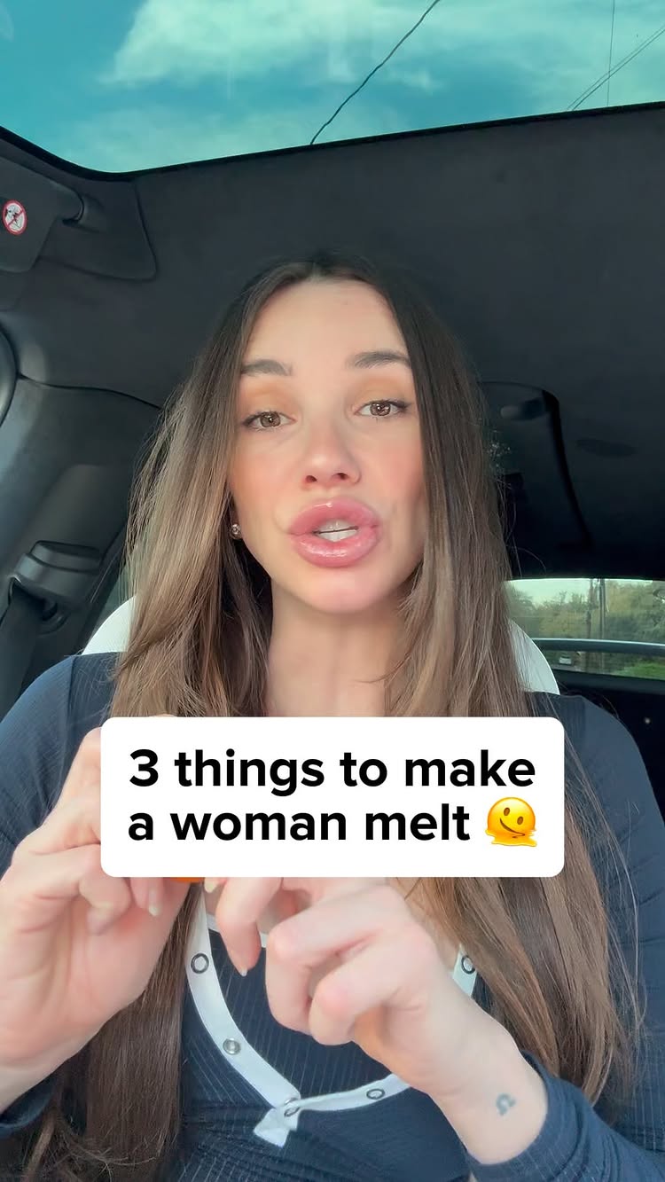 A woman is seated inside a car, facing the camera. She has long, light brown hair and is wearing a dark top. A text box at the center of the frame, in white, reads "3 things to make a woman melt" with a smiling emoji.