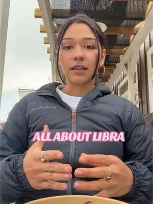 A medium shot of a person, likely a female, looking directly at the camera and speaking. She has dark hair pulled away from her face with visible ear piercings. She's wearing a dark jacket. Below is a text overlay in a pink box.