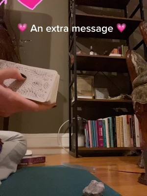 A hand holding a deck of tarot cards is centered in the image, with a blurred background including bookshelves and a corner of a room with dim, warm lighting. Text overlays are added.