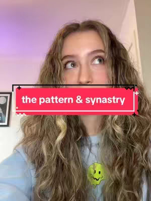 A young woman with long, wavy hair and a light-colored shirt is looking upwards with a thoughtful expression. A red rectangular overlay with white text reading "the pattern & synastry" covers part of the image. A small drawing of a yellow smiley face is featured on the shirt.
