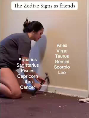 A woman kneels on a maroon floor, appearing to work on a baseboard. She holds a hammer near the wall. Text overlays list zodiac signs.