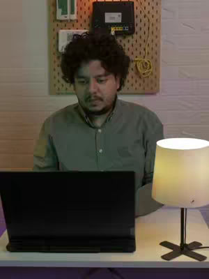 The cover image features a man sitting at a desk with a laptop. The room is dimly lit with a lamp on the desk. The background includes a pegboard with electronic equipment. The man is looking intently at the laptop screen.