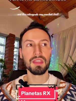 A man with a beard is centered in the frame, speaking directly to the camera. He wears a patterned sweater and has a microphone attached to his collar. The background includes a wooden ceiling, brick wall, and hints of greenery. Overlayed text reads 'Planetas RX' and 'Planetas Retrógrados'.
