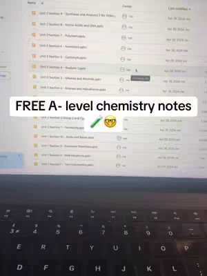 A laptop screen is visible, displaying a file directory with various folders and labeled files. Overlayed on the image is a text bar containing information related to A-level chemistry notes and displayed over the keyboard and screen. The keyboard letters are in white and the screen has light gray folder names.