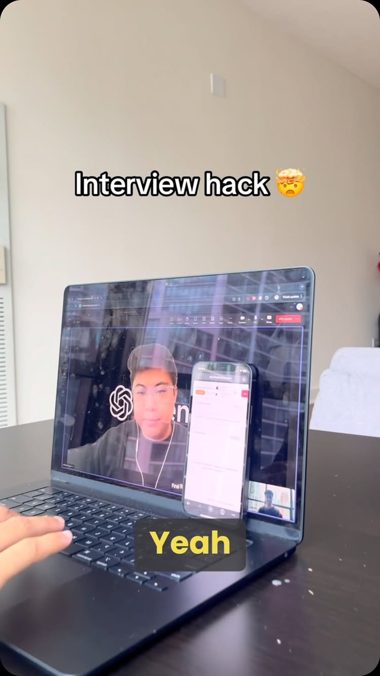 The cover image shows a person in the middle of a video call using a laptop. The laptop screen displays a video call with a person. A smartphone is leaning against the laptop showing an app interface. The text overlay reads "Interview hack." and "Yeah."