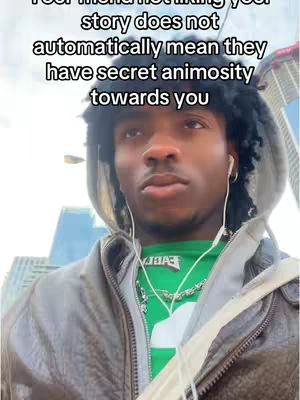 A young man in a hoodie is the central focus, standing outside with buildings in the background. Text overlays the image, and he is wearing earbuds. The color palette is muted, with a focus on greens and grays from the hoodie and surrounding environment.