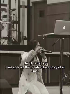 A sepia-toned image features a woman holding a microphone and singing in what appears to be a church or performance stage. The background includes a musical setup with instruments and stage lighting. Text overlayed in the image reads 'Then I found out I was apart of the greatest love story of all time.'