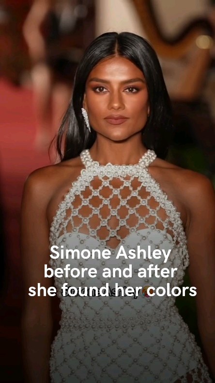 The image showcases Simone Ashley, a woman with dark hair and a fair complexion, framed from the chest up. She is wearing a stylish white, beaded, halter-neck dress. The colors appear to be vibrant with a softly blurred background that complements her skin tone. The text overlay reads, "Simone Ashley before and after she found her colors."