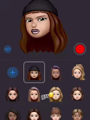 The cover image is a screenshot from an app, likely an emoji creator. A character face, styled as an emoji with facial accessories, is displayed at the top-center. The character has brown hair beneath a black beanie, intense expression, and a small piercing. The background is dark, and below the character is a selection of similar character faces, probably to make a selection.