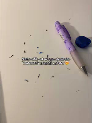A white surface is covered with blue eraser shavings, a purple pen with paw print design, and a blue eraser in the upper right corner. Text in a black font overlayed on the image indicates it is about studying.