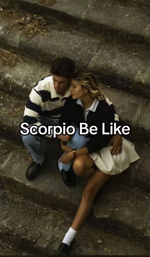 The photograph shows a couple embracing on a stone staircase. A man in a striped shirt and jeans sits on the left, while a woman in a white skirt and black top leans into him on the right. A small child is between them. The image has a warm, slightly faded aesthetic.