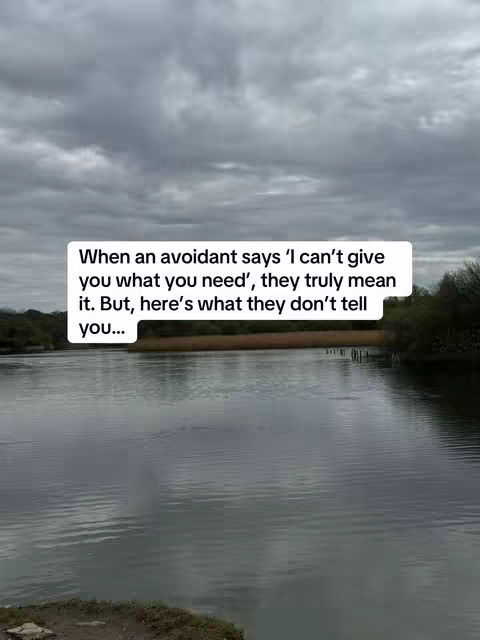 A serene landscape with a body of water in the foreground under an overcast sky. A text overlay in a white rounded rectangle is placed on the water's surface.