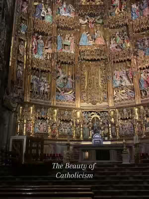 An interior shot of a church with a heavily decorated altar in the background. The altar is covered in detailed carvings and statues, with gold accents. Dark wooden pews lead up to the altar.