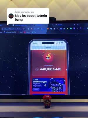 The image shows a phone displaying an app interface, with a small figure in front. The phone screen is the central focus, showing a financial app with a red and orange color scheme. The app displays a balance and a logo. In the foreground, a small figurine of a character is placed, adding a playful contrast to the digital display in the background. The scene is set inside, with a computer screen visible behind the phone, with the text overlay that is floating on the image.