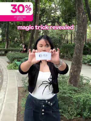 A woman with long black hair holds a card in front of her face in an outdoor setting, with the word 'magic trick revealed' overlaid along with a 30% off banner.