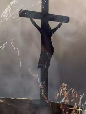 The image depicts a silhouette of the crucifixion of Jesus. The cross is dark, against a backdrop of a bright, blurry light which obscures much of the background, possibly suggesting a cloudy sky or fog. The figure on the cross is also in silhouette, and the overall tone is somber and reverent, evoking the theme of Holy Week and Good Friday.