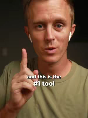 A man with fair skin, wearing a green shirt and white earbuds, points upwards with his right index finger. Text overlays the image, reading "and this is the #1 tool".
