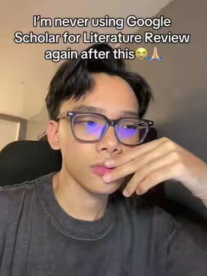 A young man with dark hair and glasses is centered in a close-up shot, with text overlaid at the top. The background is blurred and features warm lighting.