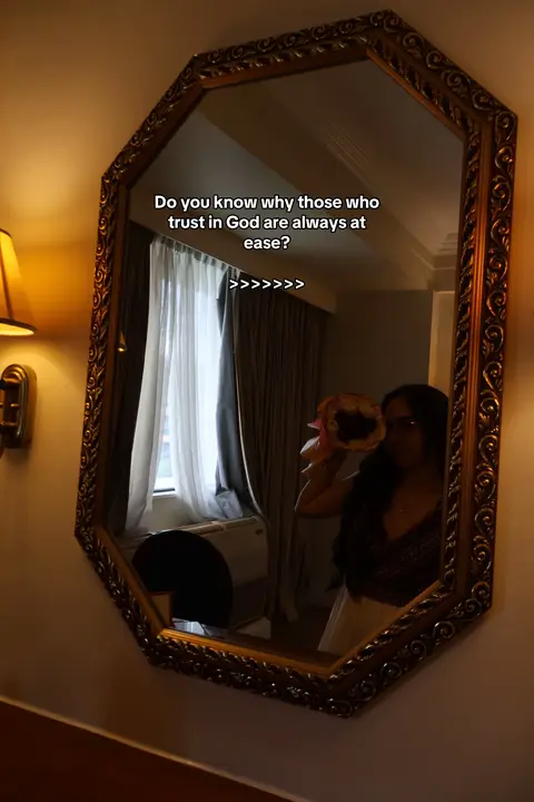 The cover image shows a well-decorated room featuring a large, ornate, octagonal mirror. The mirror reflects a woman holding flowers and part of a window with curtains. Text is overlaid on the mirror. The overall composition has a warm tone, likely due to the lighting from a nearby lamp.