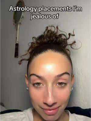 A selfie-style image featuring a young woman with light skin and brown curly hair styled in a top-bun. The background is a plain, light-colored wall with a tennis racket hanging. The woman has a neutral expression, looking at the camera, with the hook text above her centered.